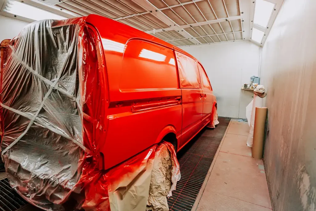Red work van in paint booth